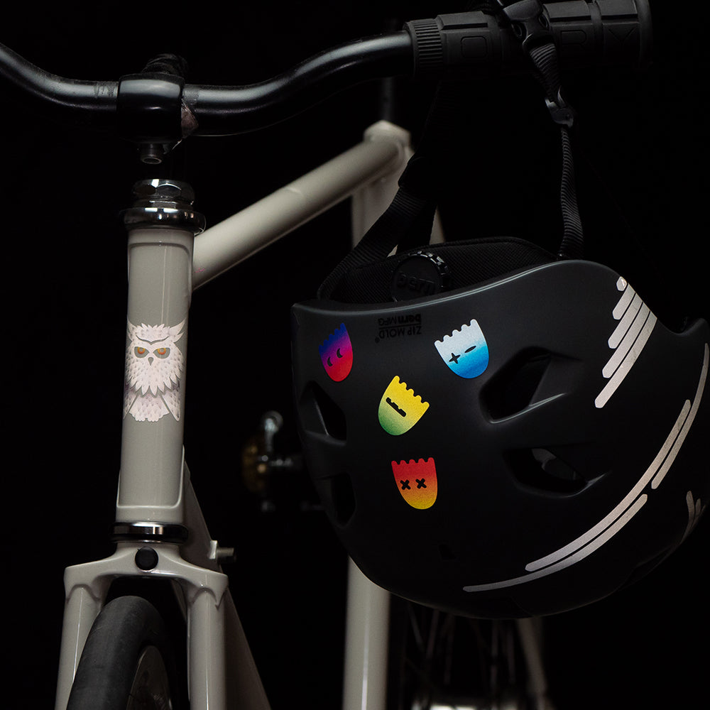 Fahrrad mit Helm am Lenker, im Dunkeln, mit reflektierenden Aufklebern