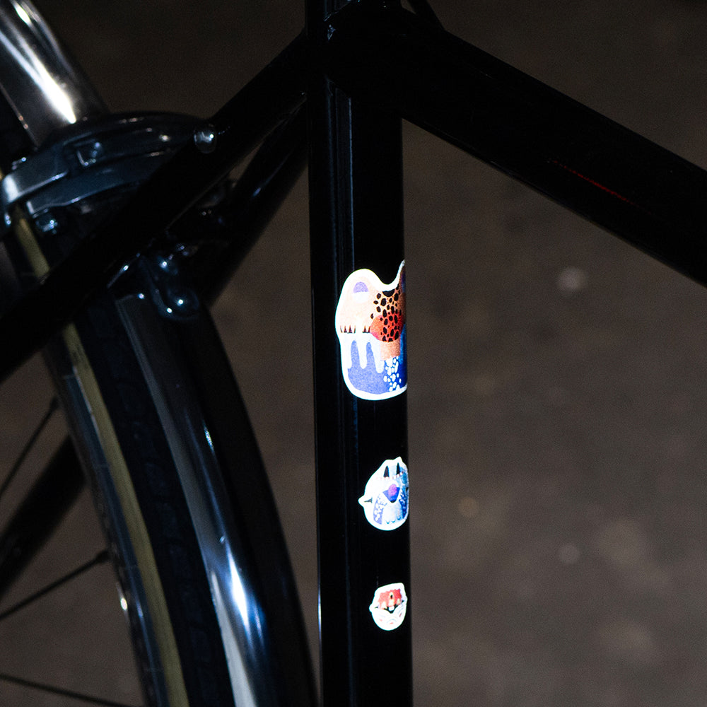 Artist sticker from Kurihara, on black bicycle at night