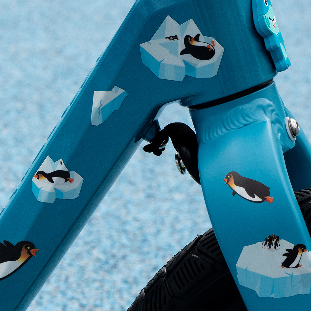 Close up of reflective penguin sticker set on kids bike with blue background