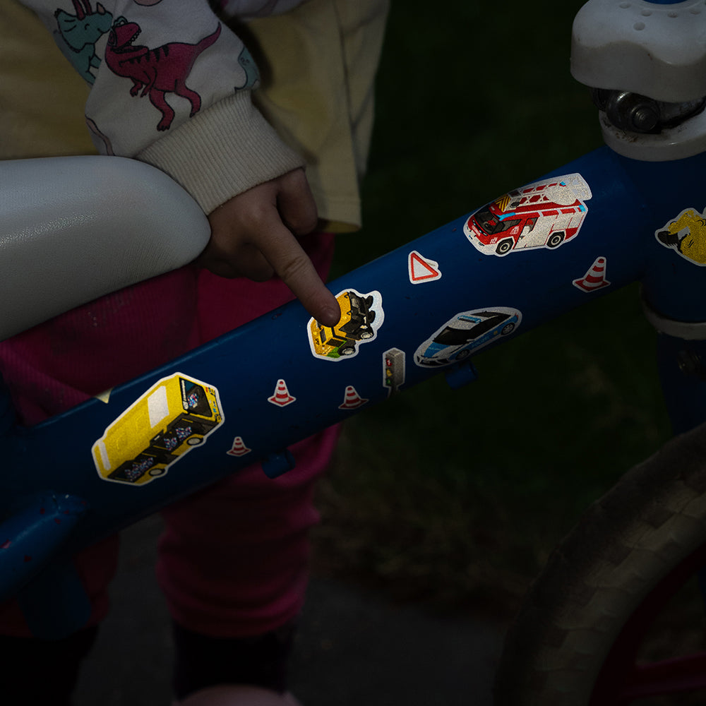 Reflective sticker with car design and kid pointing at the design, at night with reflection