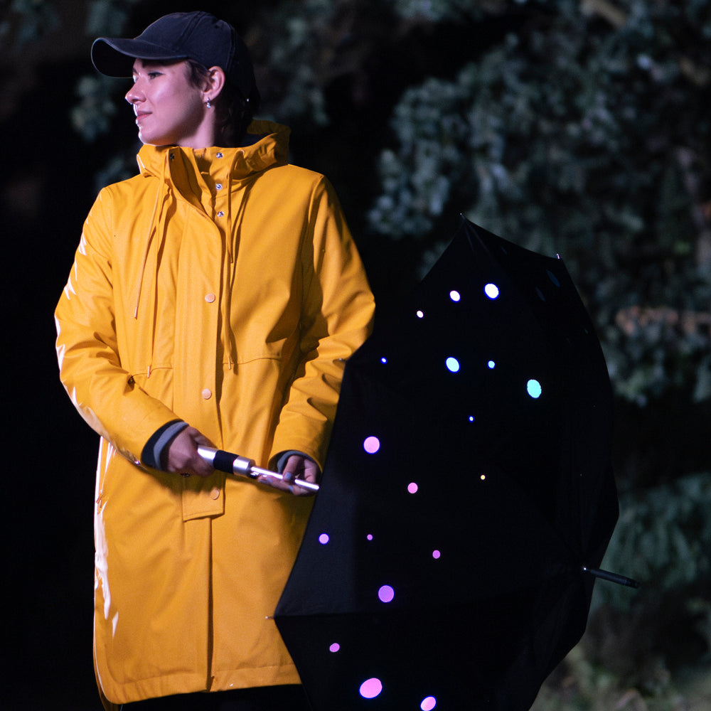 Woman with umbrella wearing yellow rain jacket.