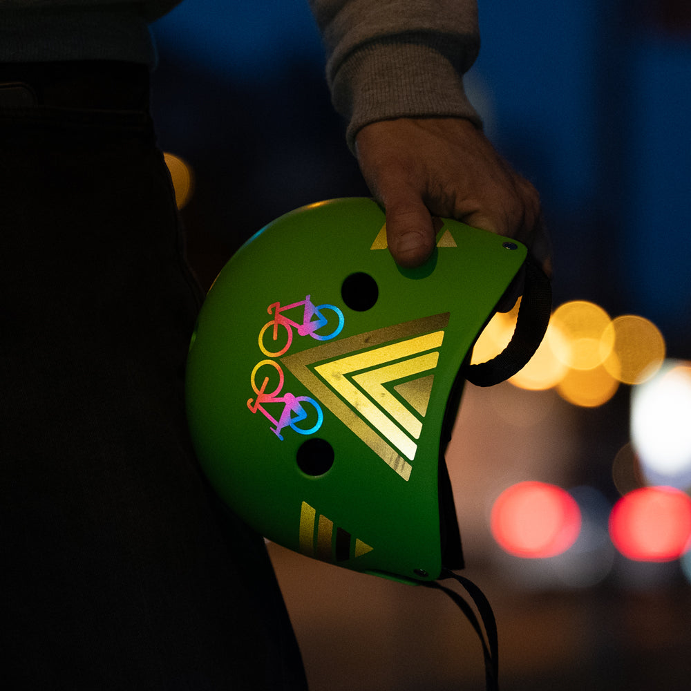 cargo mini reflective sticker on helmet held by hand and night city background