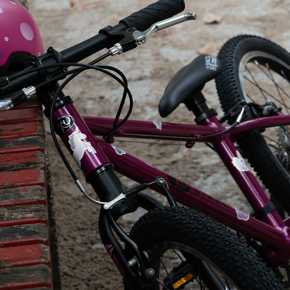 purple bicycle laying on a bench with helmet