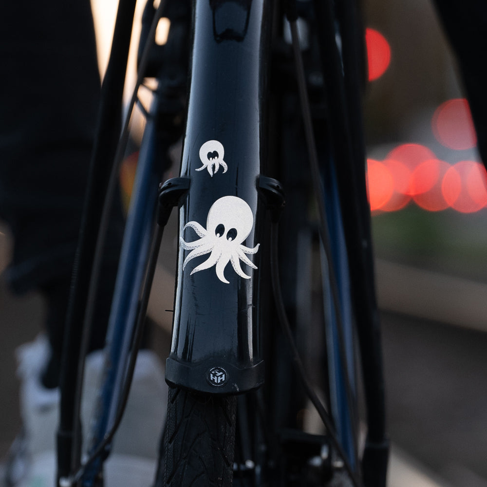 Back of a bicycle , reflective sticker on mudgard and blurry background lights 